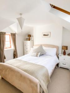 a bedroom with a large white bed and a window at Pen Y Bont Cottage Llanuwchllyn Bala in Llanuwchllyn