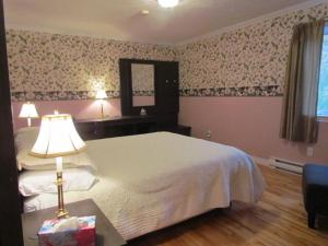a bedroom with a bed and a table with a lamp at Shepody Bay Inn in Hopewell Cape