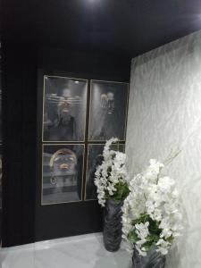dwie wazy z białymi kwiatami na stole ze zdjęciami w obiekcie Willa Sandomierska w mieście Sandomierz