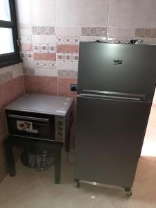 a refrigerator and a stove in a kitchen at Résidence Aden إقامة عدن in Laayoune