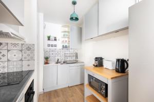 uma cozinha com armários brancos e uma bancada em Charming and Natural T2 neuf - Hyper-centre Meaux - Disneyland Paris em Meaux
