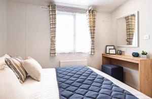a bedroom with a bed and a desk and a window at Hedgehope Retreat in Swarland