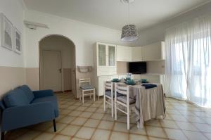 uma sala de estar com uma mesa e um sofá azul em A&B Homes Leuca em Leuca