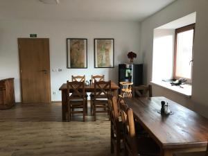 a dining room with a wooden table and chairs at Penzion U Kostela in Kuželov