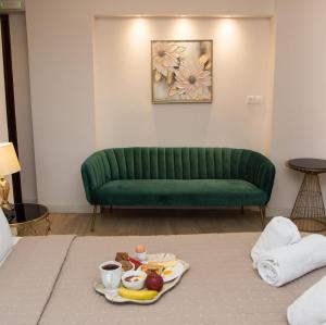 a green couch in a room with a tray of food at Arxontiko Hotel in Myrina