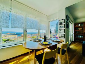 jadalnia ze stołem z krzesłami i dużym oknem w obiekcie Apartment AlMare w mieście Opatija