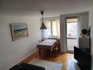 een woonkamer met een tafel en een keuken met een raam bij Mieszkanie na Orlej 300 metrów od plaży! in Gdańsk