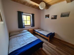 1 dormitorio con 2 camas y ventana en KURNACHATA, en Wetlina