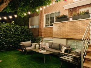 a patio with a couch and chairs and a table at Loft de estilo industrial con jardín y garaje privados in Valladolid