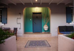 a hallway with a blue door and a vase at Villa Primarosa in Metaxáta