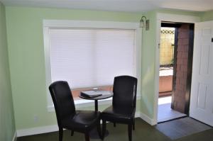 a dining room with two chairs and a table and a window at Beachfront Manor Hotel in Lincoln City