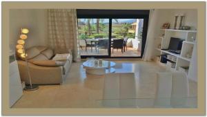 a living room with a couch and a table at LUXUS APARTMENT am Meer in Estepona