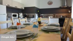 - une table avec des assiettes et de la vaisselle dans la cuisine dans l'établissement Gîte L'échappée Belle !, à Saint-Aignan