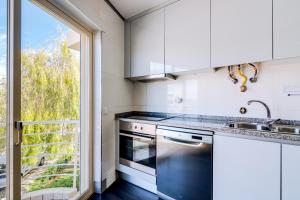 ヴィラモウラにあるAL - Apartamento Terracos da Falesiaの白いキャビネットと大きな窓付きのキッチン