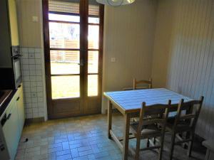 eine Küche mit einem Tisch, Stühlen und einer Tür in der Unterkunft Gite La Bicyclette in Godewaersvelde