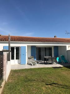 a house with a patio with a table and chairs at La Maison Oceane in Dolus d'Oléron