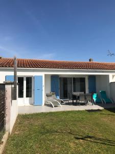 una casa con un patio con mesa y sillas en La Maison Oceane, en Dolus d'Oléron