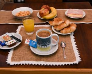فندق كاسا كالما في سانتو تومي: طاولة مليئة بفنجان من القهوة والمعجنات