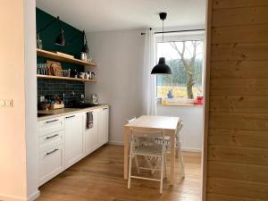 a kitchen with white cabinets and a table and a window at Na dziko! Bieszczady - Dom w Bieszczadach in Lutowiska