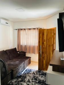 - un salon avec un canapé brun et une fenêtre dans l'établissement Casa para temporada, à Buriti