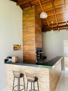 a kitchen with a counter with two stools at Casa para temporada in Buriti
