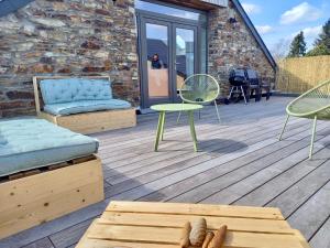 - Terraza con cama, sillas y mesa en Le grenier de Charlotte, en Libin