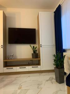 a living room with a television on a wall at Apartament Fordon przy Onkologii in Bydgoszcz