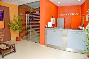 a lobby with orange walls and a reception desk at Dream Hotel in Sliven