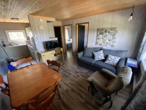 a living room with a table and a blue couch at The Pines Motel and Cottages in Rustico