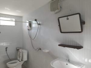 a bathroom with a toilet and a mirror and a sink at Stay Ban Posai with Pool in Prakhon Chai