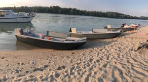 three boats sitting on the shore of a beach at Futrinka Vendégház in Baja +10 photos