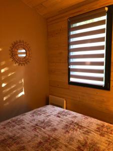 a bedroom with a bed and a window with a mirror at Fanjeaux Aude Le Chalet in Fanjeaux