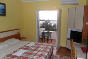 a hotel room with a bed and a balcony at Apartments Marović in Luštica