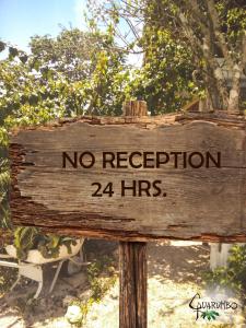 a wooden sign that says no reception hrs at Guarumbo in Bacalar
