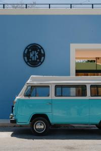Hostik Hostal في ميريدا: سيارة فان زرقاء وبيضاء متوقفة أمام مبنى