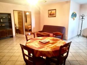 um quarto com uma mesa com cadeiras e um sofá em Gîte de Leni - Maison avec piscine em Torreilles