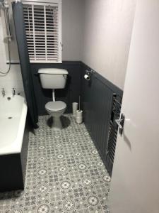 a bathroom with a toilet and a sink at Sinclair Bay Apartments in Keiss