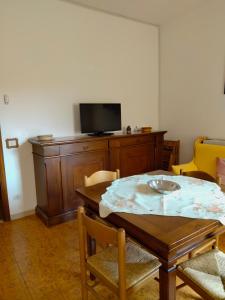 a dining room with a table and a tv at Costa degli Etruschi in San Vincenzo