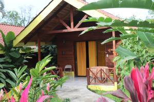 una casa con una puerta amarilla y algunas plantas en Selvita Lodge Arenal, en Fortuna