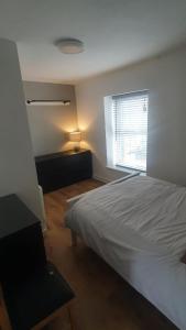 a bedroom with a white bed and a window at 3 Story House near Bike park Wales & zip world in Aberaman
