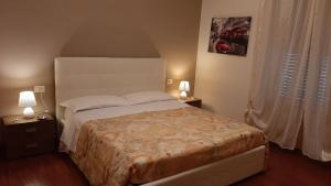 a bedroom with a large bed with two night stands and a window at Dolci Ricordi in Bari