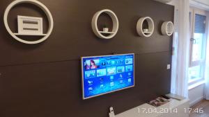 a flat screen tv hanging on a wall with mirrors at Apartment Trnje in Zagreb