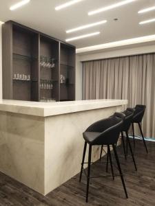 a lobby with a bar with black stools at Baruk Guadalajara Hotel de Autor in Guadalajara