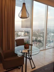 a living room with a glass table and a chair at Baruk Guadalajara Hotel de Autor in Guadalajara