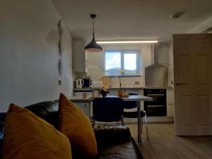 a living room with a couch and a table in a kitchen at Curlew's Nest in Ruthin