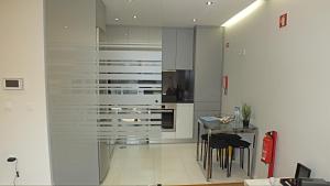 cocina con armarios blancos y mesa en Valadim Flats_2T, en Oporto