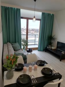 a living room with a table and a couch at AL Mare Apartament in Gdańsk