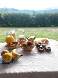 a table topped with baskets of fruit and orange juice at Posada La Sofia in Tafí del Valle