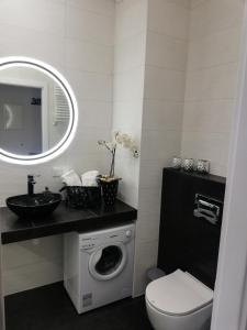 a bathroom with a washing machine and a sink at AL Mare Apartament in Gdańsk