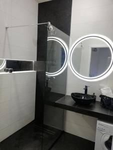 a bathroom with a sink and a mirror at AL Mare Apartament in Gdańsk